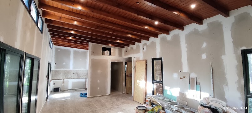 Interior vivienda KIKUE — vigas de madera expuestas, iluminación embutida, planta abierta